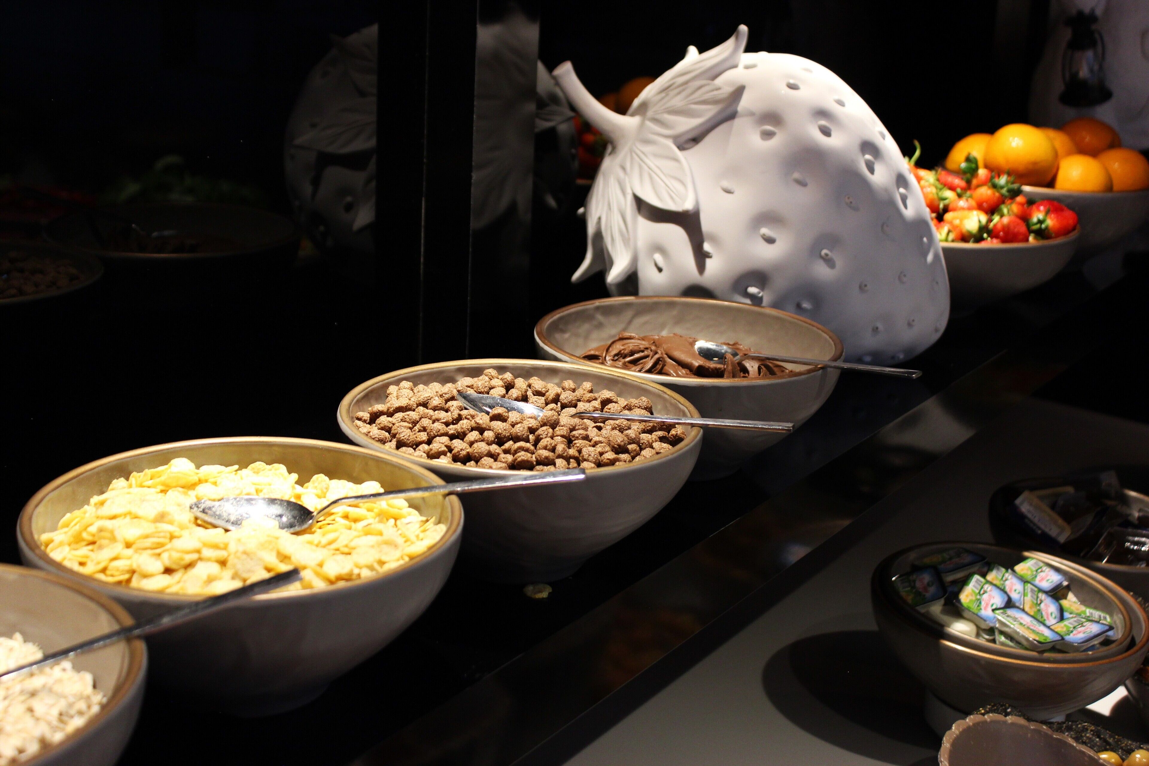 Ein reichhaltiges Buffet mit verschiedenen Speisen, darunter Getreideprodukte, Nüsse und Früchte.