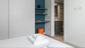 A modern bathroom with a white sink, a mirror, and a towel rack.