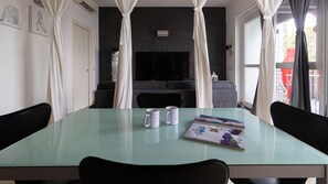 A modern living room with a glass-top dining table, two white mugs, and a magazine. - Italianway Comfort - Savona 123 (Milan)