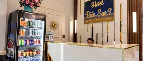 A hotel reception area with a marble counter, a Pepsi vending machine, and a sign reading "Hotel Bien Saô 2".