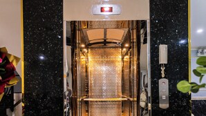 An elevator with a glass door, a control panel, and a decorative floor pattern. - Bien Sao 2 Hotel- Nguyen Van Luong  (Ho Chi Minh City)