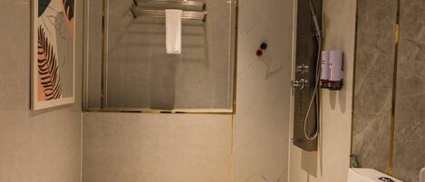 A modern bathroom with a shower, toilet, and a sink.