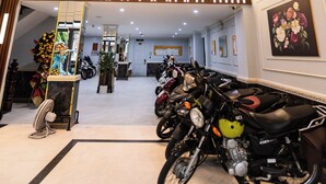 A spacious hotel lobby with a high ceiling, a chandelier, and a row of parked motorcycles. - Bien Sao 2 Hotel- Nguyen Van Luong  (Ho Chi Minh City)