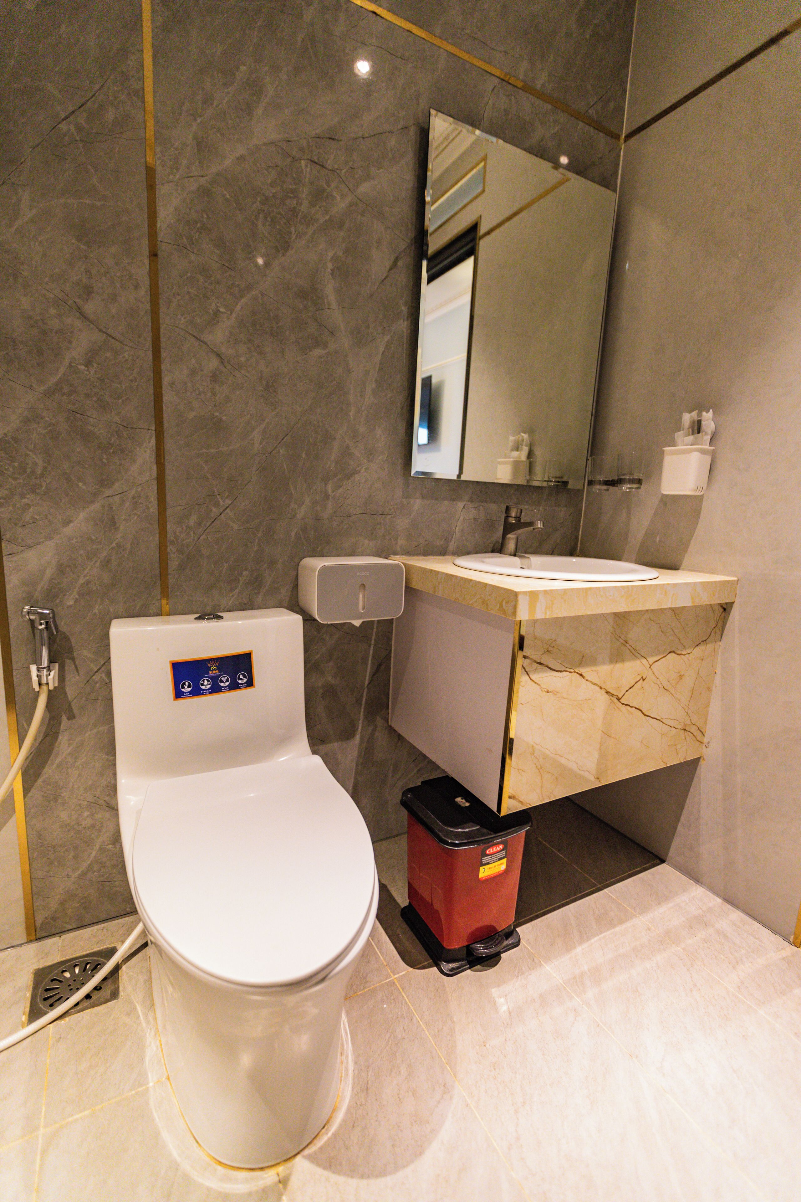 A modern bathroom with a toilet, sink, and mirror.