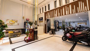 A hotel lobby with a reception desk, seating area, and a row of parked motorcycles. - Bien Sao 2 Hotel- Nguyen Van Luong  (Ho Chi Minh City)