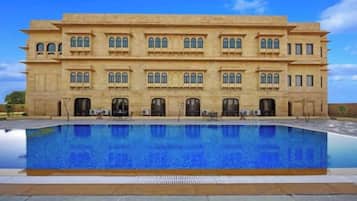 A large building with a swimming pool in front.