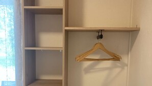 Une armoire en bois dotée de plusieurs étagères et d’un portant en bois.