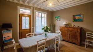 Un comedor con una mesa dispuesta para cuatro, un armario de madera y un cuadro en la pared.