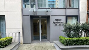 A modern building entrance with a glass door, labeled "Aegean Apartments 37-73". - Royal Docks Luxury 3 Bedroom Apartment (London)