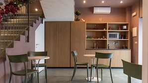 A modern interior with a staircase, a kitchen area, and seating arrangements. - Opera Boutique (Catania)