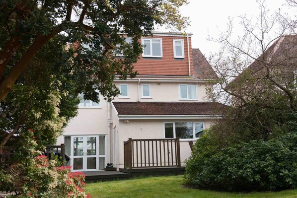 A two-story house with a front garden, a wooden fence, and a garage. - Mumbles - House - Seaside - Sleeps11 - Petfriendly (Swansea)