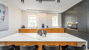 Eine moderne Küche mit einer großen Kochinsel, Holzschränken und einer Marmorarbeitsplatte.
