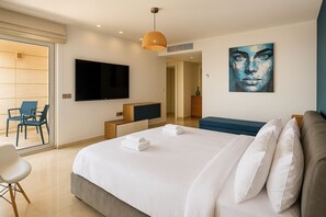 Relax in a spacious room with a large bed, flat-screen TV, and comfortable seating area.