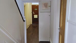 A narrow hallway with a wooden floor leading to a door marked "EXIT". - PRIVATE ROOMs In TOWN CENTRE FREE PARKING WIFI AND PATIO WITH AA STAY LTD (Aylesbury)