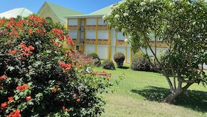 Un bâtiment doté d’un toit végétalisé, entouré de jardins bien entretenus et de plantes en fleurs.