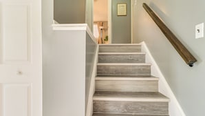 A staircase with wooden steps and a white handrail. - Westland Family Home w/ Deck & Fenced Yard (Westland)
