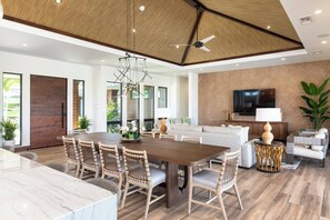 Relax in this stylish living area with a large dining table, flat-screen TV, and lush greenery.