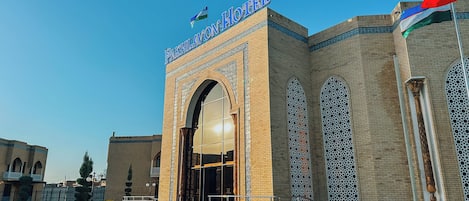 A hotel entrance with a prominent archway and decorative brickwork.
