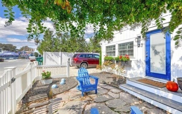 A house with a blue door, a red car parked in front, and a blue chair outside. - JUST STEPS TO THE BEACH AND DOG FRIENDLY! (DEWEY BEACH)