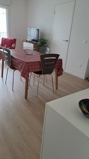 Enjoy meals in this cozy dining area with a dining table, chairs, and a mounted TV.