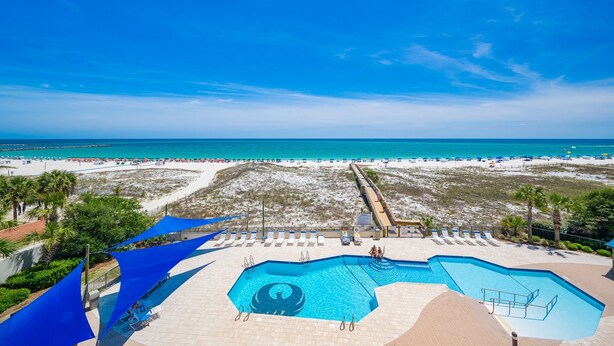 Un resort con piscina, spiaggia e vista sull'oceano.