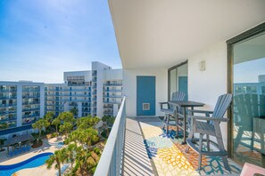 Ein Balkon mit Blick auf ein Schwimmbecken und angrenzende Gebäude.
