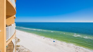 A beach view with a building on the left. - Phoenix Orange Beach 1604 3 Bedroom Condo (Orange Beach)