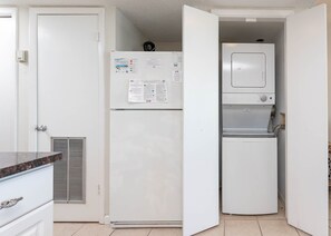 A compact kitchen with a refrigerator, a built-in water dispenser, and a microwave. - Gulf Shores Surf & Racquet 605a 1 Bedroom Condo (Gulf Shores)