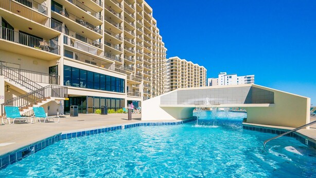 En swimmingpool med en modern byggnad i bakgrunden.