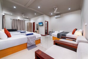 A hotel room with two beds, a sofa, a TV, and a ceiling fan. - Palm Oasis At Ukulhas (Ukulhas)