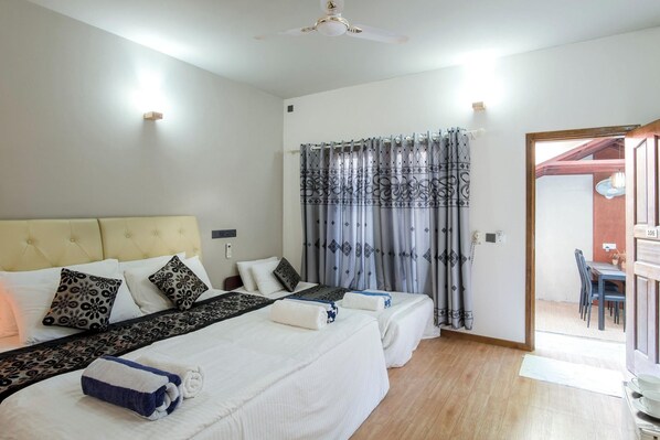 A hotel room with two beds, a ceiling fan, and a view of the outside. - Palm Oasis At Ukulhas (Ukulhas)