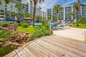 Un resort con piscina, sillas de descanso y una terraza de madera.