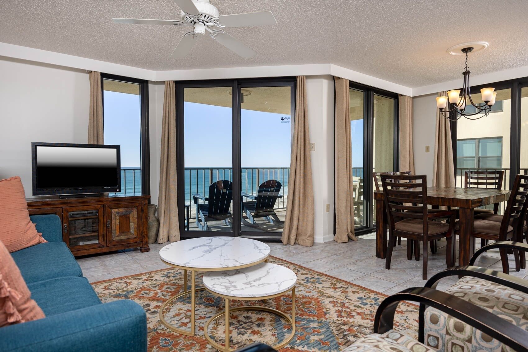 A spacious balcony with a TV, seating area, and a dining table.