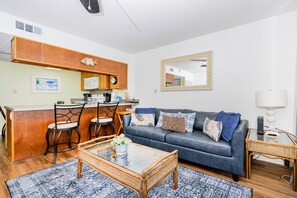 Un espacio habitable compacto con kitchenette, un sofá, una mesa de centro y un comedor.