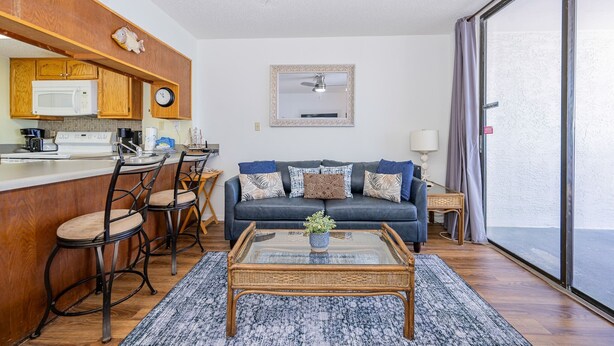 A compact living space with a kitchenette, a sofa set, and a dining area. - Gulf Shores Surf & Racquet 712a 1 Bedroom Condo (Gulf Shores)
