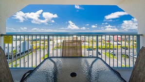 A balcony with a view of a parking lot and buildings. - Gulf Shores Surf & Racquet 712a 1 Bedroom Condo (Gulf Shores)