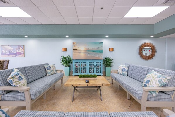 A room with two sofas, a coffee table, and a painting on the wall. - Phoenix East 608 1 Bedroom Condo (Orange Beach)
