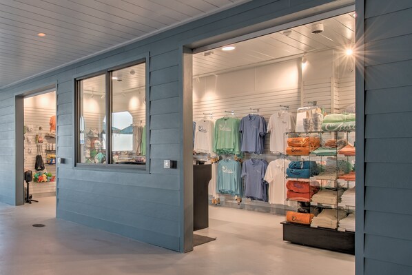 Una tienda de ropa con perchas llenas de camisas y prendas dobladas.