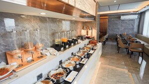 A buffet with various food stations and seating areas.