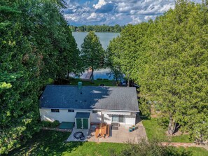 A house with a garage, a covered patio, and a view of a lake.