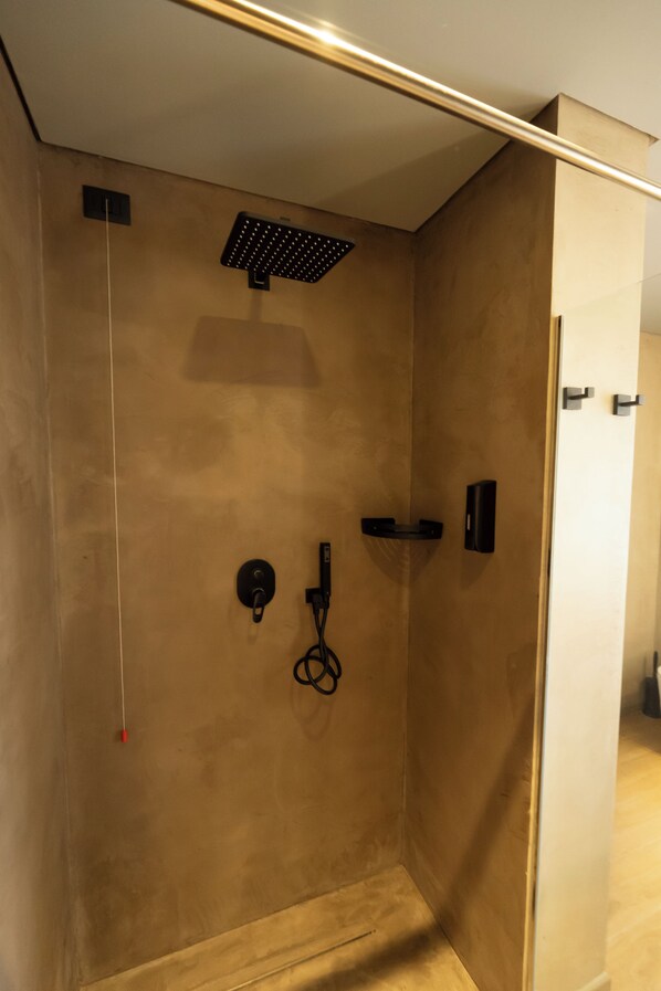 A modern shower with a control panel, a handheld showerhead, and a towel rack. - Hotel Le Rose (Briatico)