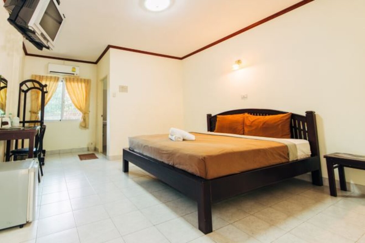 A bedroom with a bed, a desk, and a chair.