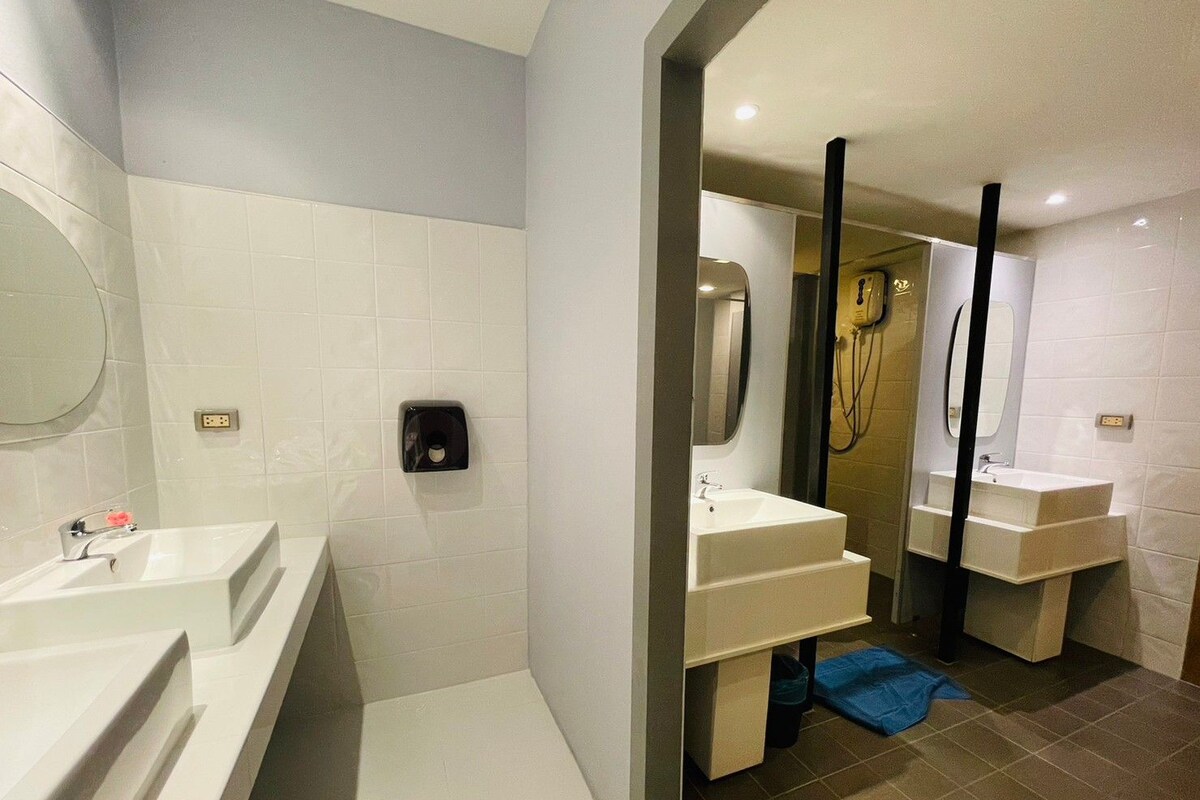 A modern bathroom with two sinks, a mirror, and a shower area.
