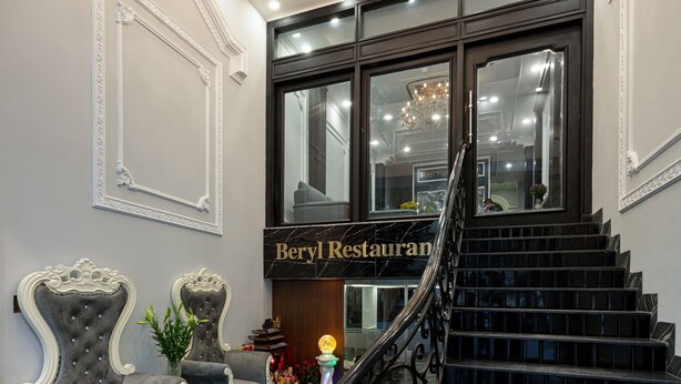 A grand staircase leading to a restaurant with marble flooring and ornate chairs. - Avani Central Hanoi Hotel (Hanoi)