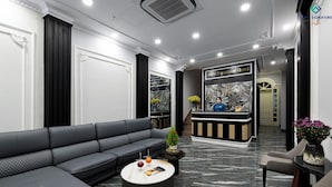 A modern hotel lobby with a black leather sofa, a marble coffee table, and a reception desk. - Avani Central Hanoi Hotel (Hanoi)