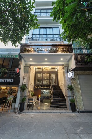 La entrada al Hotel Beryl Signature, con una escalera que lleva a la entrada, un cartel para el Restaurante Beryl, y vistas del área circundante, incluyendo un restaurante cercano.