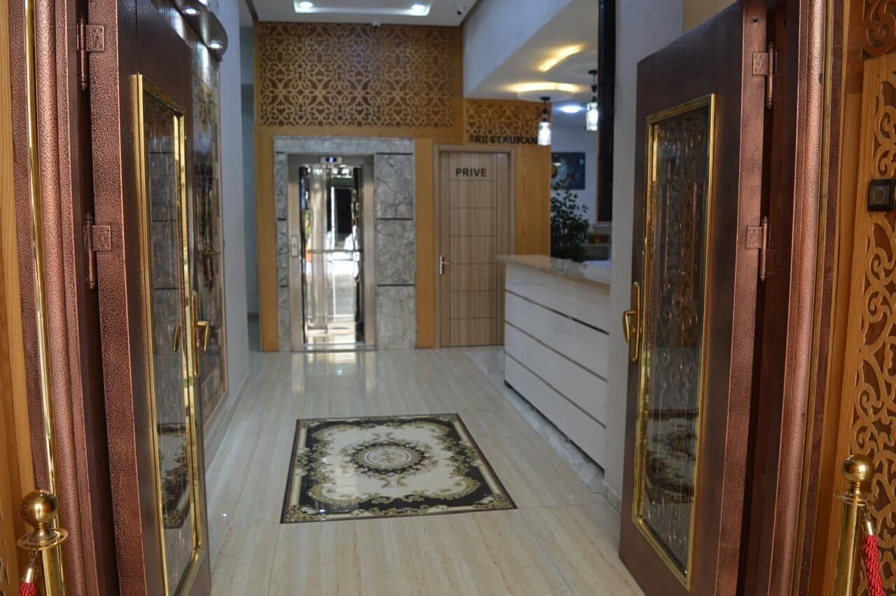 A hotel lobby with a marble floor, a reception desk, and a 'PRIVE' sign.