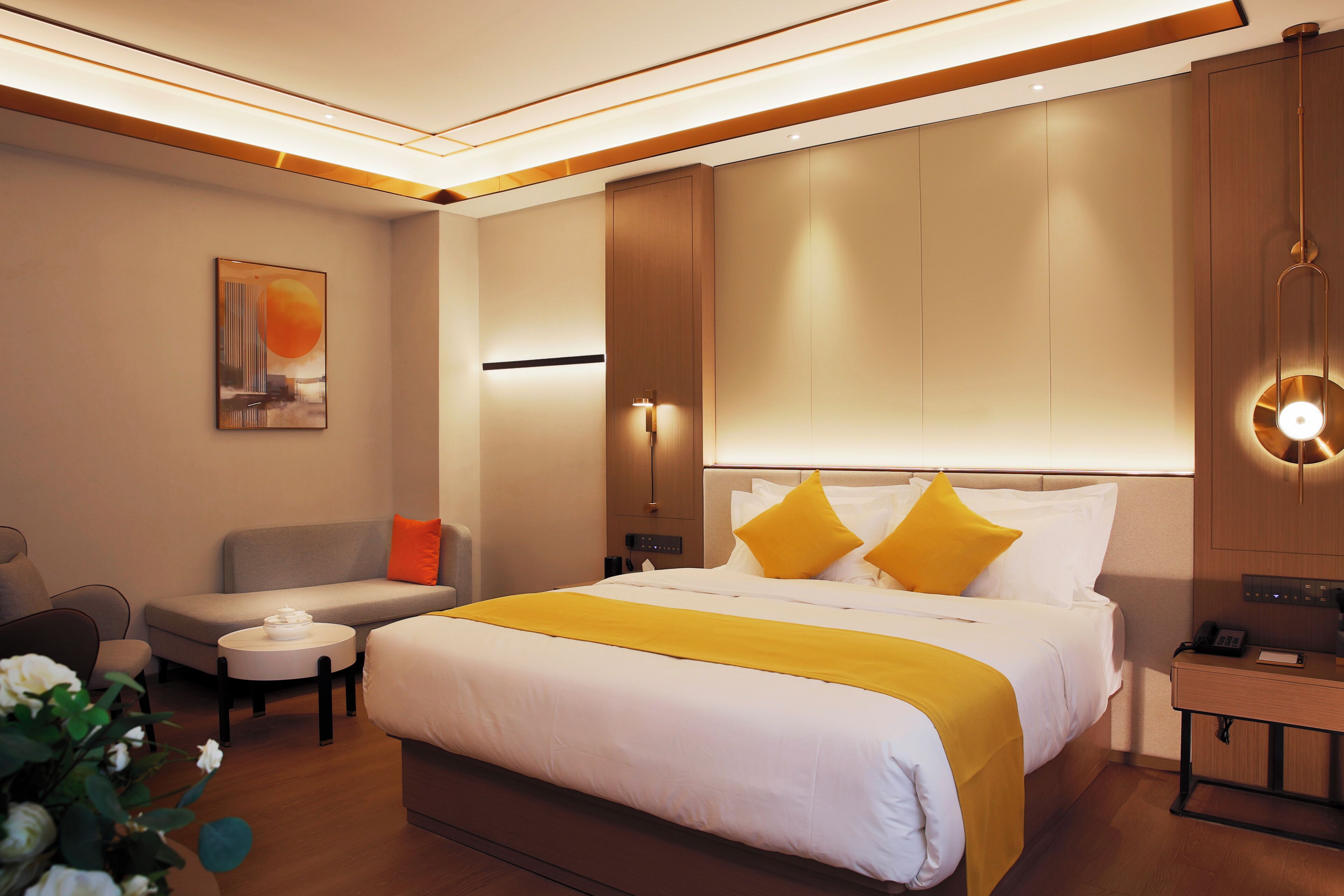 Una habitación de hotel moderna con una cama grande, un sofá, una mesita y una mesilla de noche.