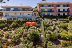 The property sits atop lush coastal gardens, with dedicated stairs leading directly to beach access—making it easy to spend your days by the ocean. - Spectacular Luxe Oceanfront Condo | Looks Toward Channel Islands & Rugged Peaks (Santa Barbara)