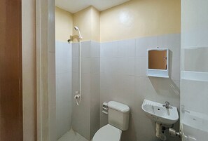 A small bathroom with a toilet, sink, and shower. - Flogel Amore Pension House (Cebu City)